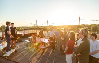 A SAIN Groningen closing evening on a rooftop terrace at sunset