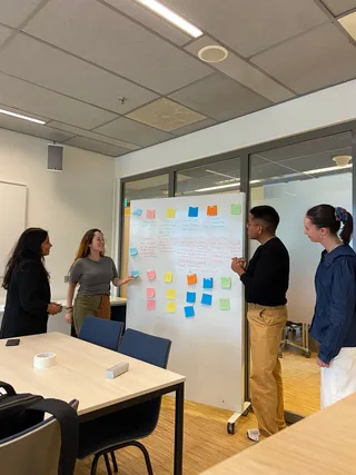 Participants mapping AI governance mechanisms on a whiteboard covered in sticky notes