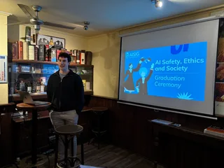 A speaker in front of the graduation slide at a Groningen ceremony
